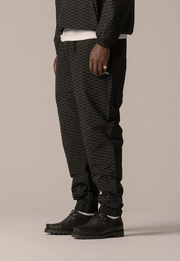 ALLOVER TRACK PANTS UNISEX - Tracksuit bottoms - black