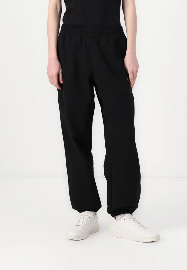 MONOLOGO - Tracksuit bottoms - black