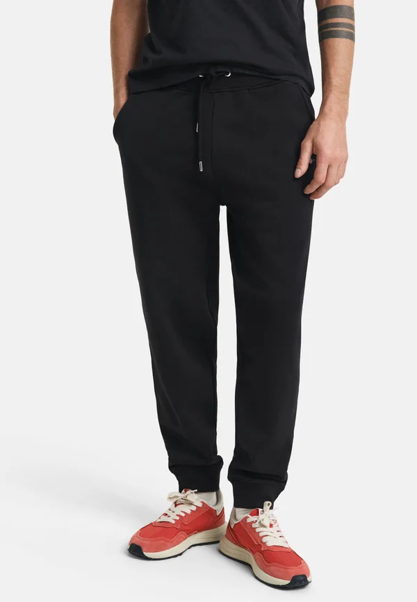 REG SHIELD - Tracksuit bottoms - black